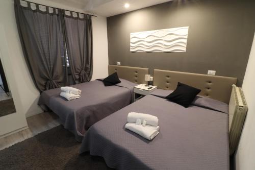 - une chambre d'hôtel avec 2 lits et des serviettes blanches dans l'établissement Guest House Minas, à Milan