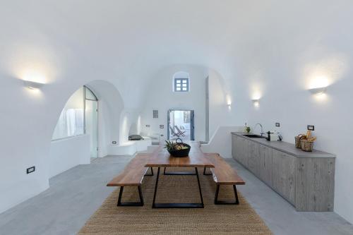 a living room with a wooden table and a counter at Alluvial Santorini Suites in Mesaria