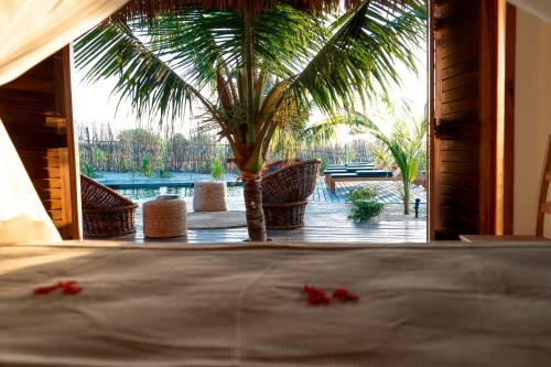 a bed in a room with a view of a palm tree at Villa Dunas by Preabeach Experience in Prea