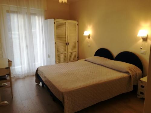 a bedroom with a bed and a large window at Aktiv Hotel Eden in Dro