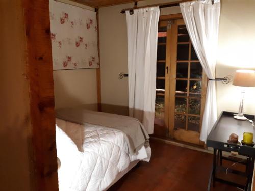 a bedroom with a bed and a window at The Tin Shack in Underberg