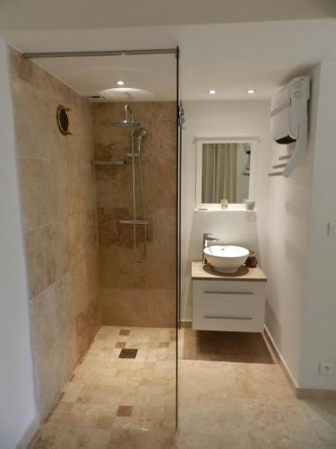 une salle de bain avec une douche en verre et un lavabo dans l'établissement La Comète, à Gassin