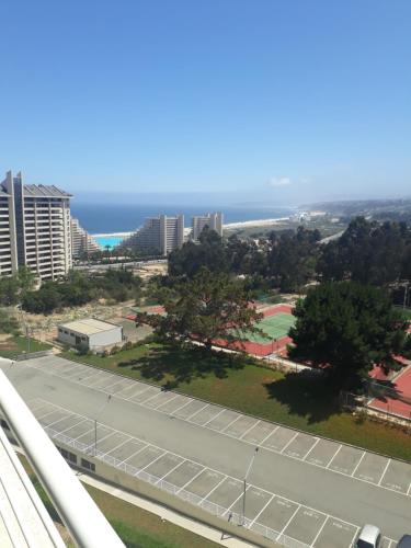 a view of a street with a parking lot and the ocean at Departamento Laguna Bahía in Algarrobo