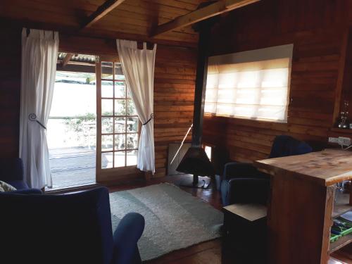 a living room with windows and a table and chairs at The Tin Shack in Underberg