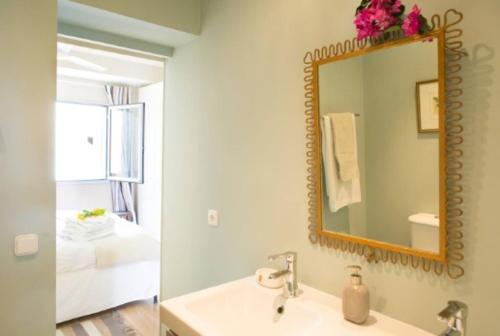 a bathroom with a sink and a mirror and a bedroom at Peaceful Top Floor Apt W Balconies - Cambridge RIGHT - AC in Funchal
