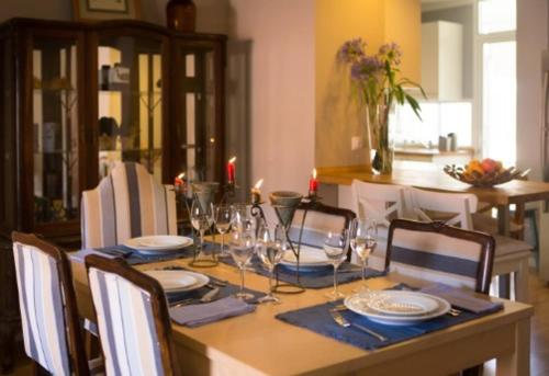 a dining room table with plates and wine glasses at Peaceful Top Floor Apt W Balconies - Cambridge RIGHT - AC in Funchal