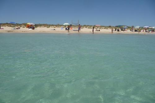 a group of people standing on a beach near the water at Affascinante Grande Liama Antica in Salve