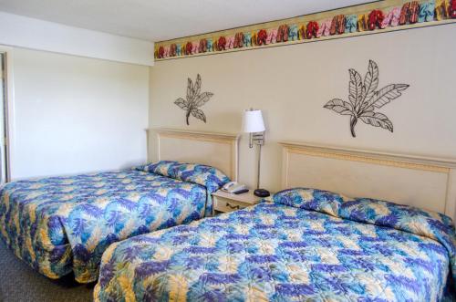 a hotel room with two beds next to each other at Palms Resort in Myrtle Beach