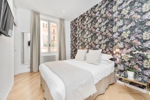 a bedroom with a floral accent wall and a bed at iFdM Mignanelli Suite in Rome