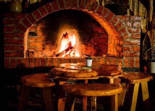 a brick oven with two wooden tables and a fire place at Rtanjski konak in Boljevac
