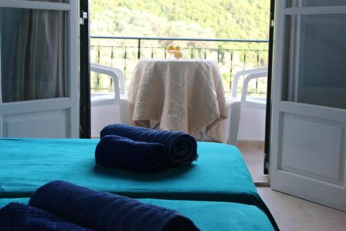 dos almohadas azules sentadas en una cama en una habitación en Natasa and Spiros, en Paleokastritsa
