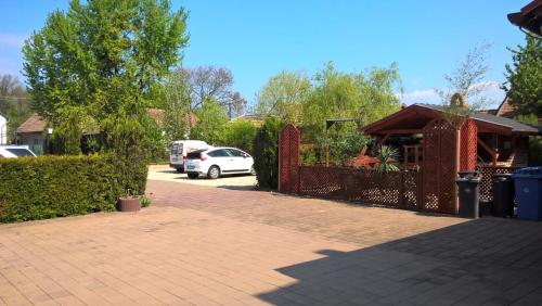 a car parked in a driveway next to a fence at Erdős Vendégház in Jánossomorja