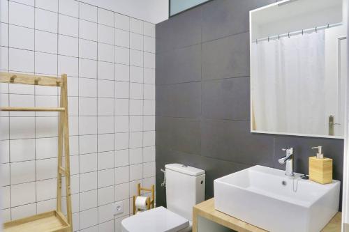 La salle de bains est pourvue de toilettes, d'un lavabo et d'un miroir. dans l'établissement Paz Velvet, Espectacular Piso en Calle La Paz, à Valence