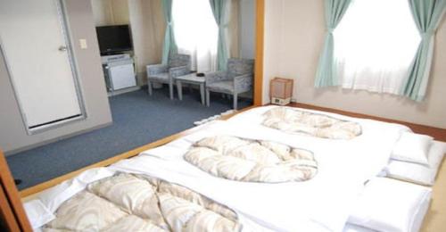 Seagrande Shimizu Station Hotel / Vacation STAY 8213 في شيزوكا: غرفة نوم بسريرين عليها مخدات