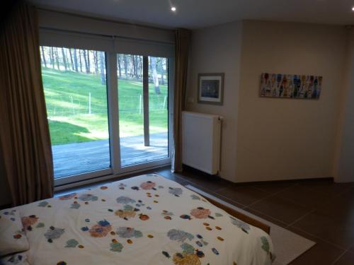 ein Schlafzimmer mit einem Bett und einem großen Fenster in der Unterkunft La Florentine in Hardelot-Plage