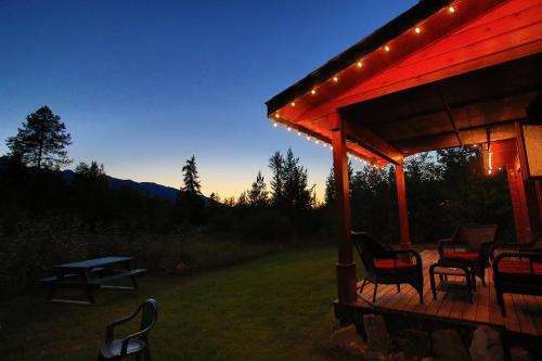 a gazebo with chairs and a picnic table at night at Mica Mountain Lodge & Log Cabins in Tete Jaune Cache