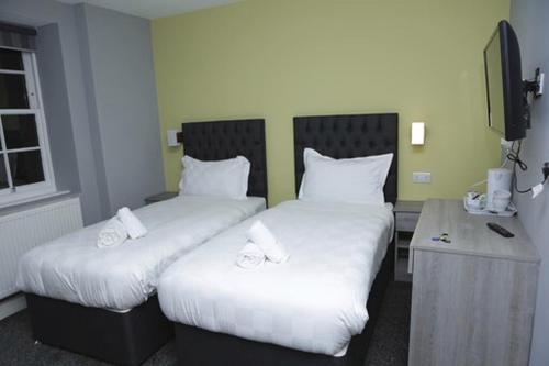two beds with white sheets in a room at The Spring Bank APARTHOTEL in Preston