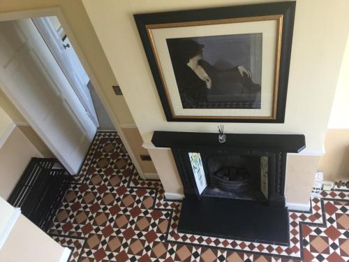 a room with a fireplace and a picture on the wall at The Lake Lodge, Wansfell Holme, Windermere in Ambleside