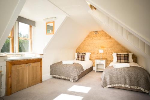 a attic bedroom with two beds and a sink at Ptarmigan in Aviemore