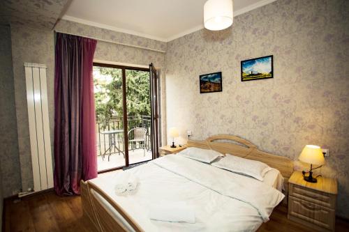 a bedroom with a large white bed and a window at Apartment Art Django Old Avlabari in Tbilisi City