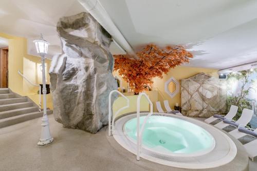 a jacuzzi tub in a room with a rock wall at Hotel Wiesental in Obergurgl