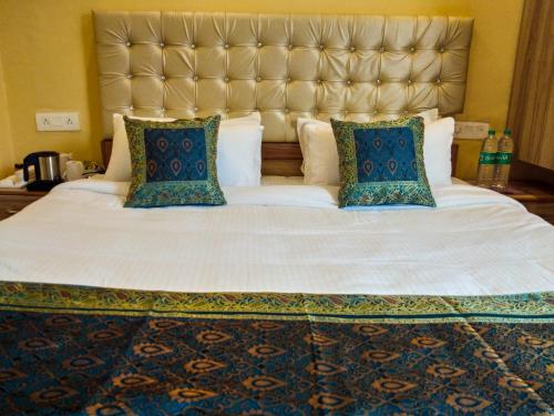 a large bed with a large headboard and pillows at Dwivedi Hotels Palace On Steps in Varanasi