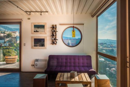 a purple couch in a room with a window at Hotel Winebox Valparaiso in Valparaíso