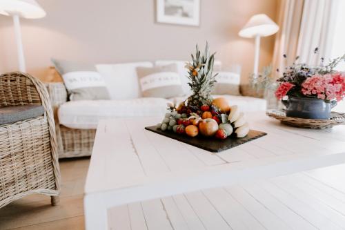 a table with a plate of fruit on top of it at StrandHotel Seeblick, Ostseebad Heikendorf in Heikendorf