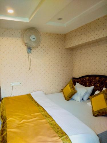 a bedroom with a bed with yellow sheets and a fan at Dwivedi Hotels Palace On Steps in Varanasi