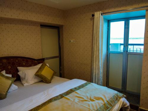 a bedroom with a bed and a large window at Dwivedi Hotels Palace On Steps in Varanasi