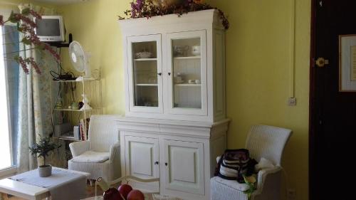 une armoire blanche dans une pièce avec deux chaises dans l'établissement Les Emeraudes, à La Croix-Valmer