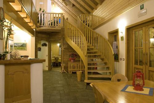 a hallway with a wooden spiral staircase in a house at Alpi Giulie Chalets in Valbruna