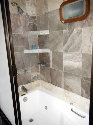a bathroom with a shower with a bath tub at Canadian Resort Huatulco in Santa Cruz Huatulco