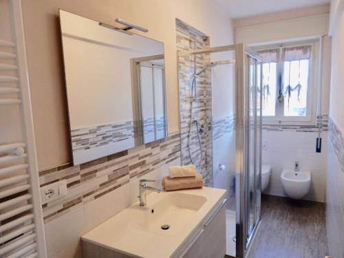 a bathroom with a sink and a toilet and a mirror at Villa La Palma in Camaiore