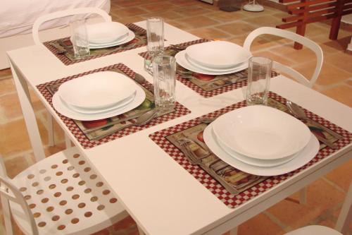 a white table with plates and glasses on it at La Masia Hotel Boutique in Anapoima