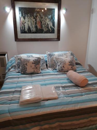 - un lit avec des oreillers et une photo sur le mur dans l'établissement Ambiente y Medio, à Mar del Plata