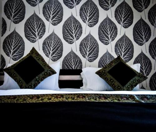 a bedroom with a black and white leaf wallpaper at Dwivedi Hotels Palace On Steps in Varanasi