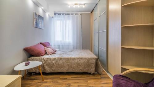 グダニスクにあるMaya's Flats & Resorts - Old Town Piwnaのベッドと窓が備わる小さな客室です。