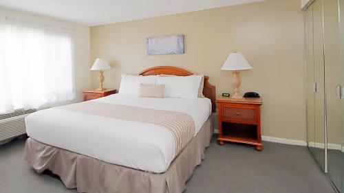 a bedroom with a large white bed and a window at The Ponds at Foxhollow by Capital Vacations in Lenox