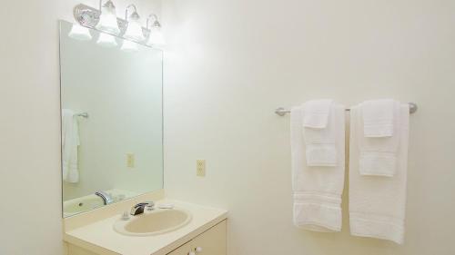 ein Badezimmer mit einem Waschbecken, einem Spiegel und Handtüchern in der Unterkunft The Ponds at Foxhollow by Capital Vacations in Lenox