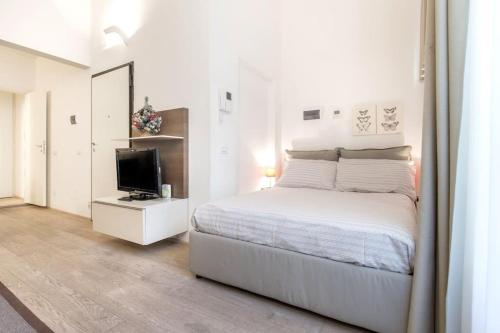 Habitación blanca con cama y TV en Santa Croce Studio, en Florencia