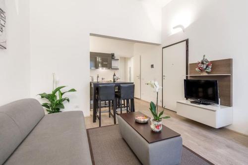 a living room with a couch and a table and a kitchen at Santa Croce Studio in Florence