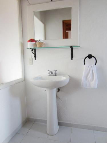 a white bathroom with a sink and a mirror at Hotel Estancia de la Era B&B in Pátzcuaro