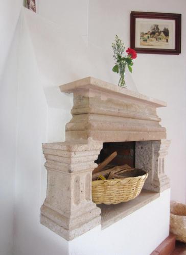 a stone fireplace with a basket on top of it at Hotel Estancia de la Era B&B in Pátzcuaro