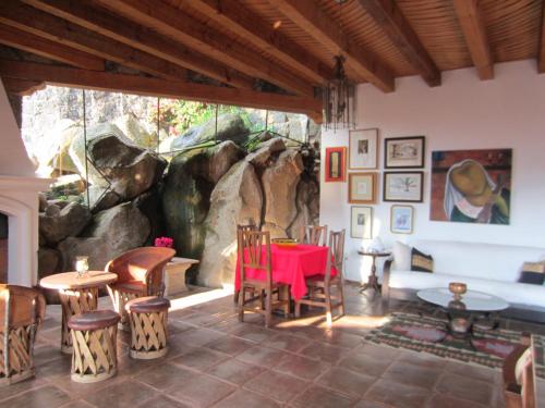 a dining room with a red table and chairs at Hotel Estancia de la Era B&B in Pátzcuaro