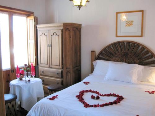 a bedroom with a bed with a heart made out of roses at Hotel Estancia de la Era B&B in Pátzcuaro