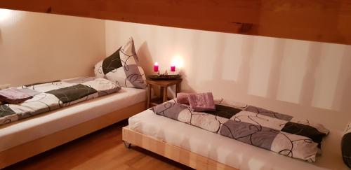 フィーバーブルンにあるVilla-Musicaのピンクのキャンドル2本が備わる客室内のベッド2台
