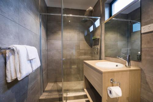 a bathroom with a glass shower and a sink at Nightcap at Playford Tavern in Elizabeth