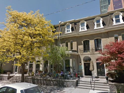 a building with a car parked in front of it at The Clarence Park in Toronto