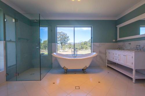 a large bathroom with a tub and a glass shower at Amani in Pokolbin